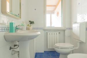 a white bathroom with a sink and a toilet at Appartamenti Belvedere by ElbaSummer in Lacona +68 photos