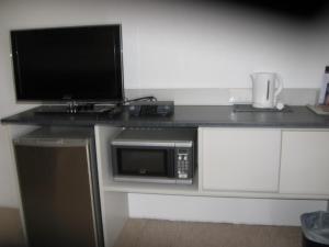 a desk with a microwave and a computer on it at Darlot Motor Inn in Horsham +6 photos