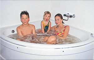 three children sitting in a bathtub in a bathroom at Beautiful Home In Vessigebro With Sauna in Vessigebro