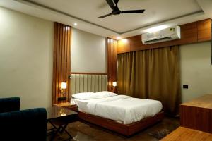 a bedroom with a bed and a ceiling fan at BANMALI REGENCY in Jamshedpur +23 photos
