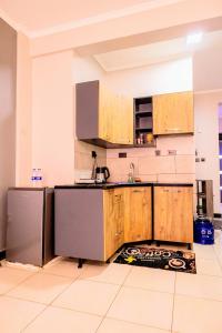 a kitchen with wooden cabinets and a sink at EKay's Space Najjera1 in Namugongo