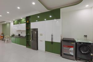 a kitchen with green and white cabinets and a washing machine at Trà Homestay in Thôn Lại Thê