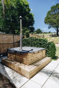 a wooden bench with a fountain in a yard at The Hamlet in Swellendam
