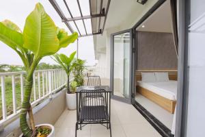 a bedroom with a balcony with a bed and plants at Trà Homestay in Thôn Lại Thê