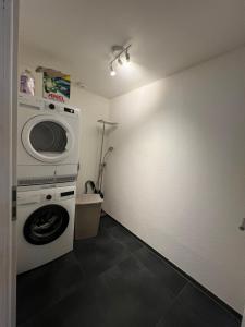 a laundry room with a washing machine and a washer at Central Living Brugg - Redapartment in Brugg