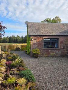 a stone house with a garden in front of it at The Cairn at North Lodge, Rural Guest Suite in Kirriemuir