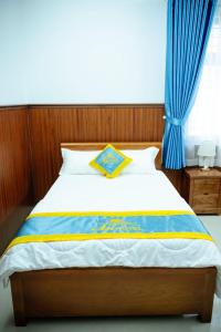 a bedroom with a bed with blue drapes at An Hotel in Xóm Vĩnh Thanh