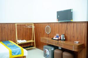 a room with a desk with a tv on a wooden wall at An Hotel in Xóm Vĩnh Thanh