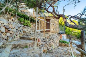 a stone wall with stairs leading up to a door at Villa Ca La Dolors - Cala Deià, by PriorityVillas in Deia