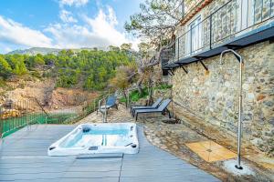 a bath tub sitting on a deck next to a building at Villa Ca La Dolors - Cala Deià, by PriorityVillas in Deia