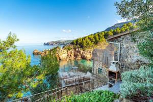 a house with a balcony with a view of the ocean at Villa Ca La Dolors - Cala Deià, by PriorityVillas in Deia