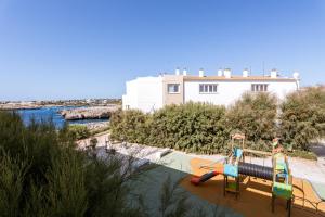 a playground with two slides in front of a building at Apartamentos Blancala in Cala Blanca
