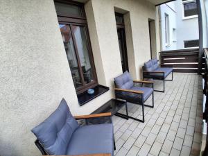 an outdoor patio with blue chairs and a building at Geräumige Stadtwohnung mit Balkon in Zwickau