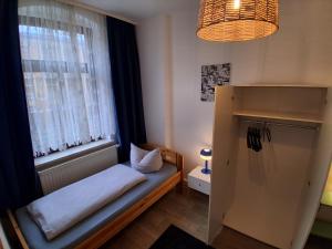 a small room with a bed in front of a window at Geräumige Stadtwohnung mit Balkon in Zwickau