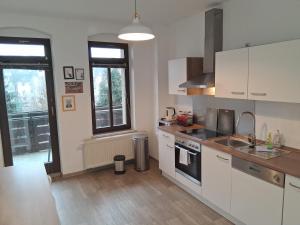 a kitchen with white cabinets and a stove top oven at Geräumige Stadtwohnung mit Balkon in Zwickau