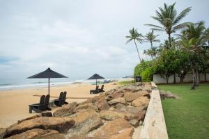a beach with chairs and umbrellas on the sand at Arabella on Boossa in Galle