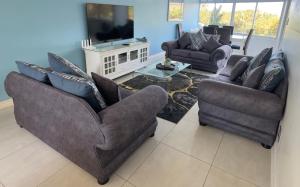 a living room with two couches and a tv at Sea Lodge G01 in Durban
