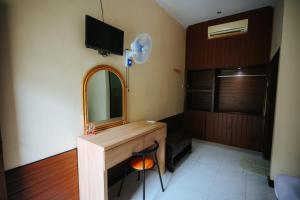 a bathroom with a vanity with a mirror and a chair at Tiffany Garden in Mangsit