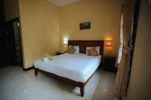 a bedroom with a bed with white sheets and pillows at Tiffany Garden in Mangsit