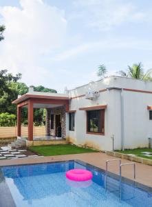 a house with a swimming pool with a pink frisbee at Ambadnya Homestays in Dāhānu