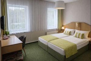 a hotel room with a large bed and a desk at Richzenhainer-Hof in Waldheim