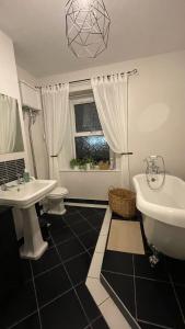 a bathroom with two sinks and a tub and a toilet at Anyas rooms Ltd in Antrim