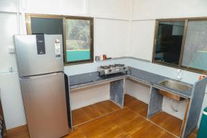 a kitchen with a stainless steel refrigerator and a sink at Ambadnya Homestays in Dāhānu