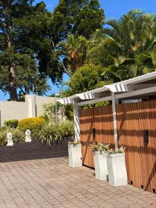a fence with potted plants in white containers at Amira Boutique Villa in Empangeni
