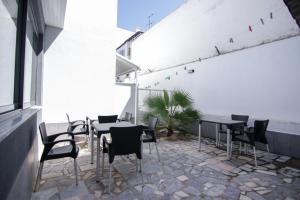 a patio with tables and chairs and a plant at QUANICE - Relaxing Guest House in Faro in Faro