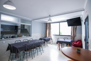 a dining room with tables and chairs and a kitchen at QUANICE - Relaxing Guest House in Faro in Faro