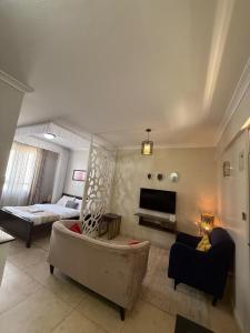 a living room with a couch and a bed at Modern Airport Studio apartment 5 mins to JKIA &SGR,Fast Wi-Fi,Ideal for layovers and longstays in Nairobi
