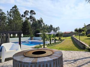a large wooden barrel with a fountain in front of a pool at Casa Aurora in Perelhal +8 photos