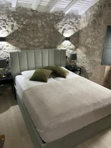 a bedroom with a white bed with a stone wall at Casa Aurora in Perelhal