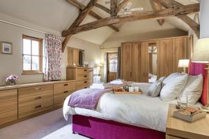 a large bedroom with a large bed and wooden cabinets at Long Barn in Ludlow