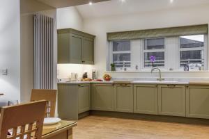 a kitchen with green cabinets and a window at Hill Top Farm in Penrith