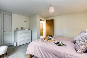 a bedroom with a pink bed and a dresser at Hill Top Farm in Penrith