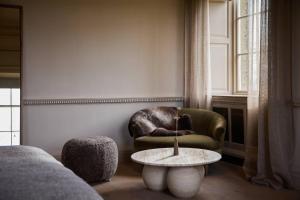 a living room with a chair and a table at Denton Hall in Ilkley +12 photos