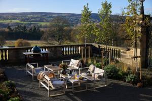 a patio with a table and chairs with a view of the countryside at Denton Hall in Ilkley