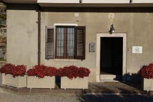 a building with red flowers in front of a window at Galbanera turismo in Albavilla