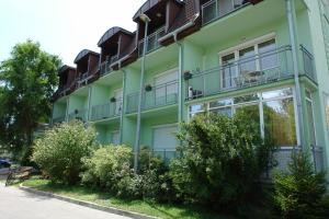a green building with balconies on the side of it at HoldLux Green Keyless 0-24 Apartman in Sárvár