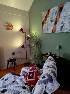 a living room with a bed and a painting on the wall at Whispering O - B&B Ermelo Speuld On the Veluwe in Ermelo