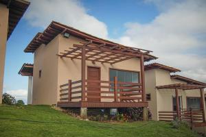 a house with a large deck on the side of it at Chalés Mirante da Colina in Venda Nova do Imigrante