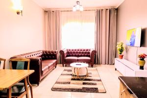 a living room with leather furniture and a table at EKay's Space Najjera1 in Namugongo