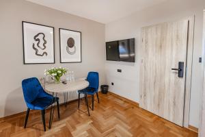 a dining room with a table and blue chairs at Hotel Zodiak in Sucha