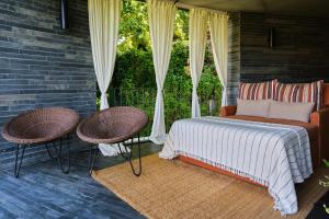 a bedroom with a bed and two chairs on a patio at Quinta do Vallado - Douro Wine Hotel in Peso da Régua