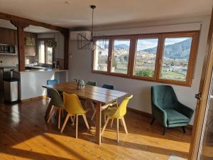a kitchen and dining room with a wooden table and chairs at ATICO RIO GENIL in Cenes de la Vega