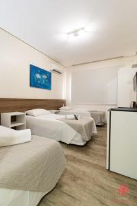 a room with four beds in a room at Hotel Geranius Ingleses in Florianópolis