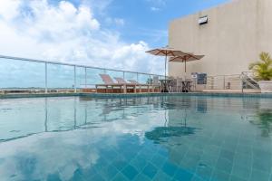 a large swimming pool next to a building at Flat Coqueiros 101 Praia in Tamandaré +19 photos