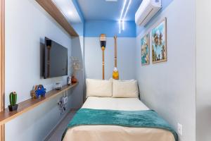 a small room with a bed and a tv at Flat Coqueiros 101 Praia in Tamandaré