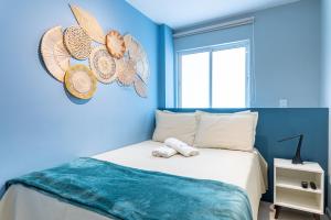 a blue bedroom with a bed with towels on it at Flat Coqueiros 101 Praia in Tamandaré